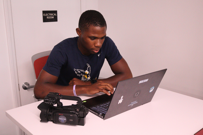 male at a desk with a laptop editing